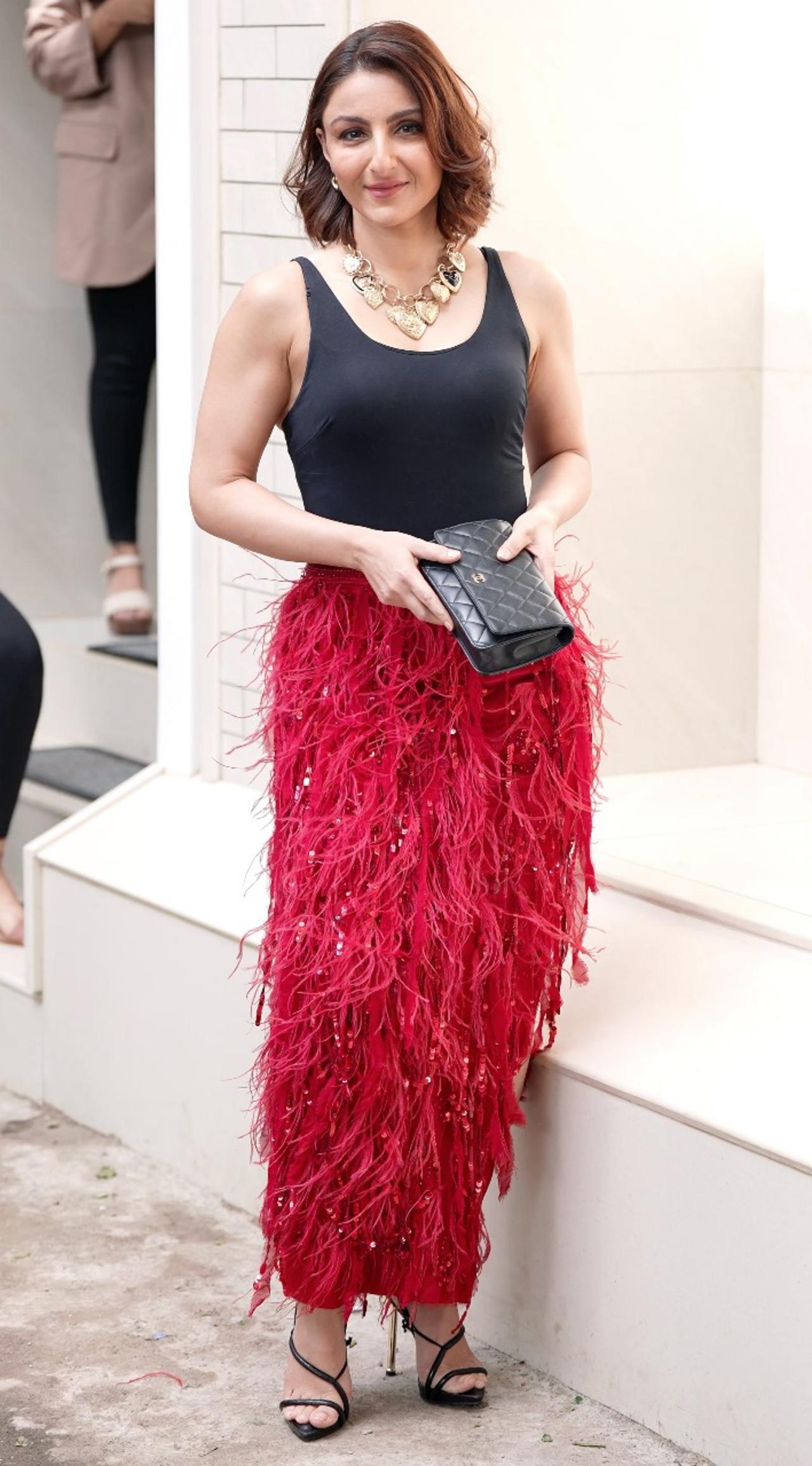 <p>Soha Ali Khan was seen in a glam mode as she stepped out in the city wearing a black camisole with a red fringe skirt. She paired it with a statement gold necklace.</p>